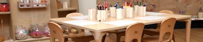 Wooden table & chairs, with pencils and paper
