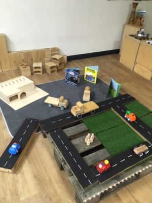 A child's play area with a train track and cars